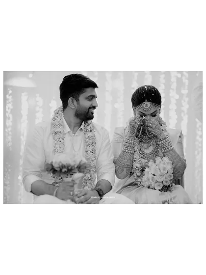 A touching black and white photo of the bride wiping away a tear of joy during the ceremony.