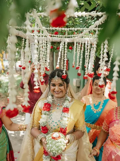 The bride's joyful entrance under a canopy of jasmine and roses, a classic and beautiful start to the wedding ceremony.