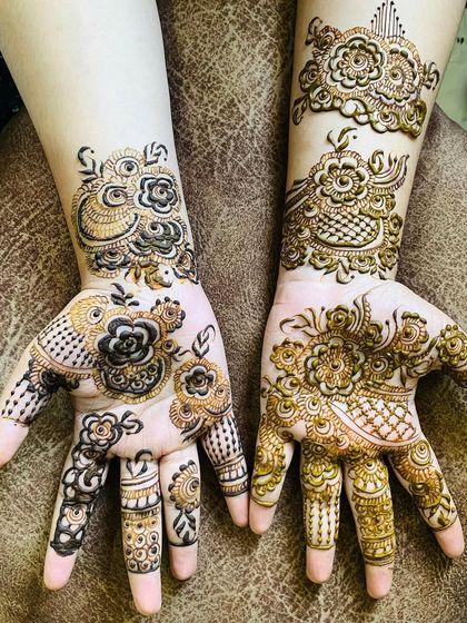 A beautiful Arabic floral design that focuses on the palm and wrist. The use of bold, filled-in flowers and leaves creates a striking contrast that is very eye-catching.