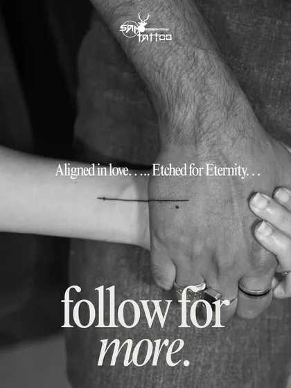 A minimalist couple tattoo. A single line connects their wrists when they hold hands, symbolizing their eternal alignment in love.