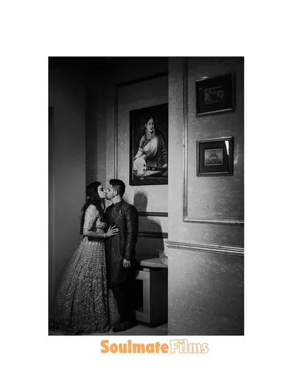 A romantic kiss captured in black and white. The classic setting and the intimate moment make for a beautiful, timeless photograph.