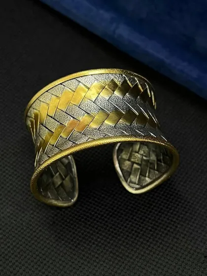 Another angle of the statement dual-tone cuff, showing the beautiful contrast and craftsmanship of the woven silver and gold-plated bands.