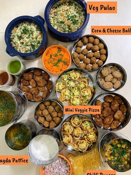 A Raksha Bandhan special spread with Veg Pulao, Corn & Cheese Balls, Mini Veggie Pizza, and Ragda Pattice.