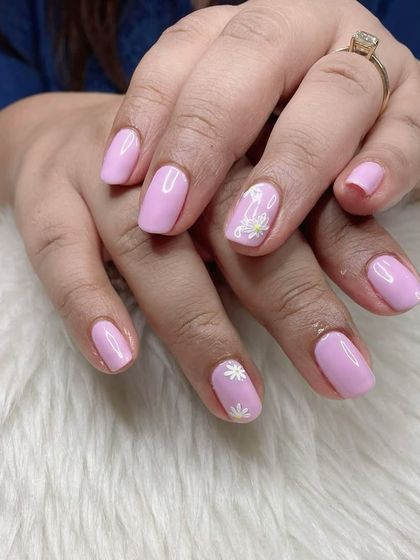 A sweet and simple pastel lavender manicure with tiny, hand-painted white daisy accents.