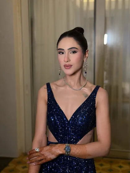High-octane glamour for an engagement party. This look features a sharp winged liner, contoured cheeks, and a sleek bun, perfectly matching the modern blue gown.