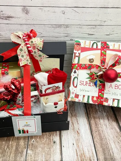 Our Christmas Collection features festive hampers for everyone. This image shows a 'Sunday in a Box' alongside a larger hamper filled with Santa-themed goodies.