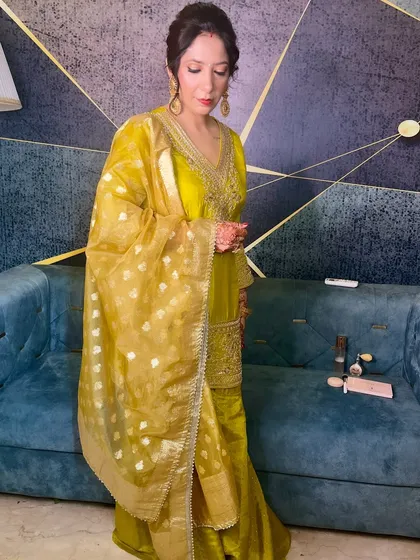 The full look, showing the beautiful coordination of the yellow suit, golden dupatta, and classic makeup.
