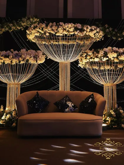The stage setup for the Sangeet, featuring a comfortable lounge sofa against a backdrop of the stunning crystal and floral installations.