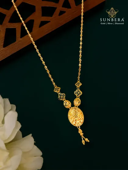A delicate gold necklace featuring intricate filigree work in its circular pendant. This piece is an example of an everyday heirloom, perfect for customers who appreciate traditional craftsmanship in a wearable, modern form.