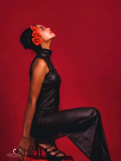 A high-fashion concept with a dramatic red dress. The pose is artistic and expressive, showcasing the flow and texture of the ruffles.