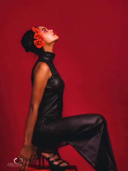 A high-fashion concept with a dramatic red dress. The pose is artistic and expressive, showcasing the flow and texture of the ruffles.