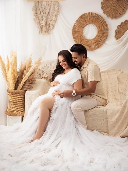 His arms wrapped around her, they both look down at the bump with love. A perfect portrait of a growing family.