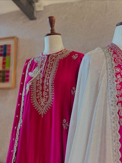 A detailed view of the signature Jayanti Reddy silver embroidery, featuring a bird motif on a rich pink silk base.