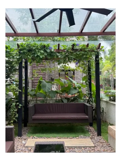 A garden swing at Chaithanya Samarpan, enveloped by climbing plants on a custom pergola. This creates a perfect, shaded nook for quiet contemplation, demonstrating how landscape elements can be designed for specific, personal experiences.
