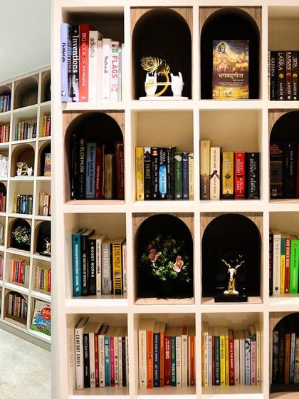 The library and reading nook from the Swami residence, comparing the render to the final photo. The arched shelves and clean white finish create a bright and organized space for the family's book collection.