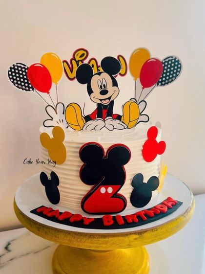 A vibrant Mickey Mouse cake for a 2nd birthday. The classic character and bright balloon toppers are always a crowd-pleaser.