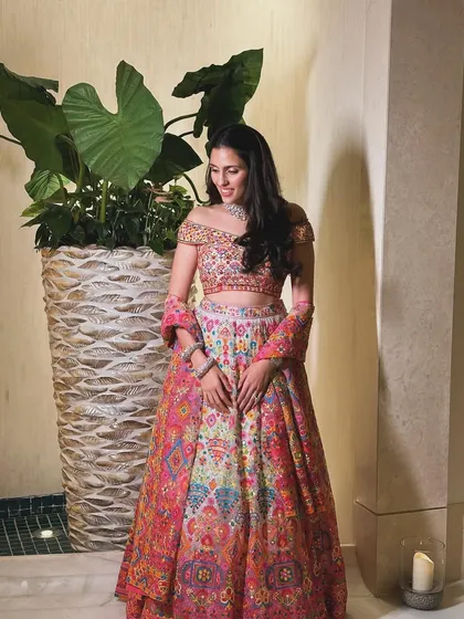 A candid shot showing the details of the Abu Jani Sandeep Khosla lehenga, a perfect rental for making a bright and cheerful statement.