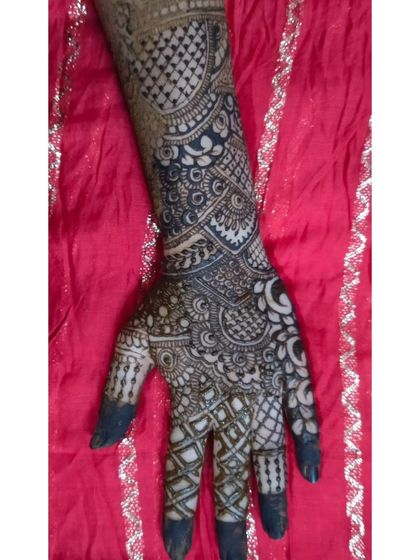 A single-hand view of a heavy, intricate design. The use of negative space around the main patterns on the back of the hand makes the artwork stand out.