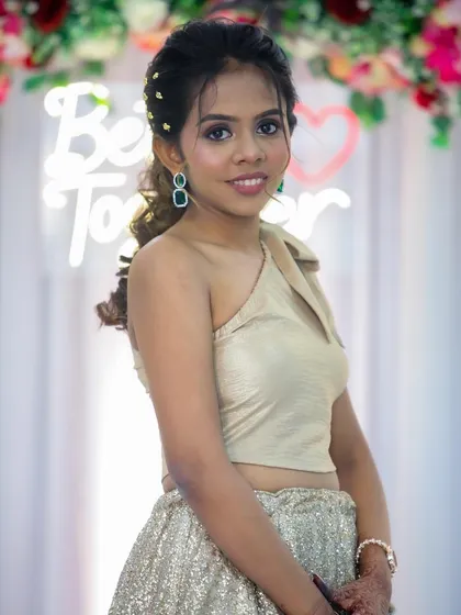 A close-up of her happy face. The green earrings add a beautiful pop of color against the neutral outfit.