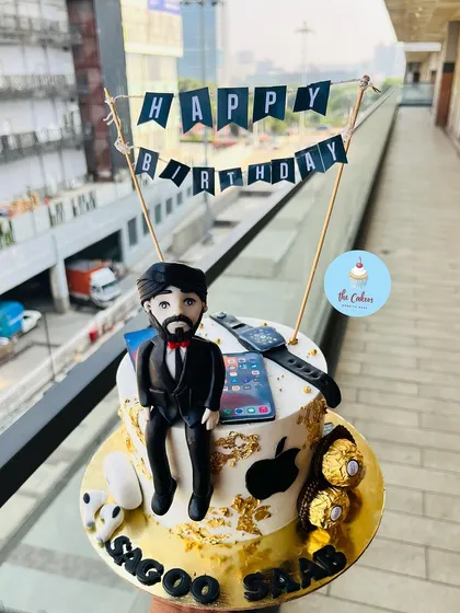 The perfect cake for the ultimate Apple enthusiast. This custom design features edible, hand-crafted fondant models of a MacBook, iPhone, Apple Watch, and AirPods, all meticulously detailed for a tech lover's birthday.