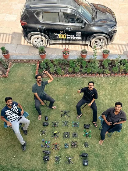 A group photo with my team and our entire drone arsenal laid out on the grass during the North India leg of my 100-day trip.