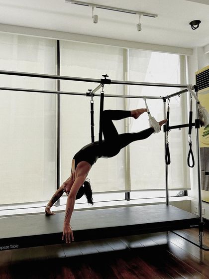 Another angle of this graceful Cadillac move, showing the full body engagement required to maintain the pose.