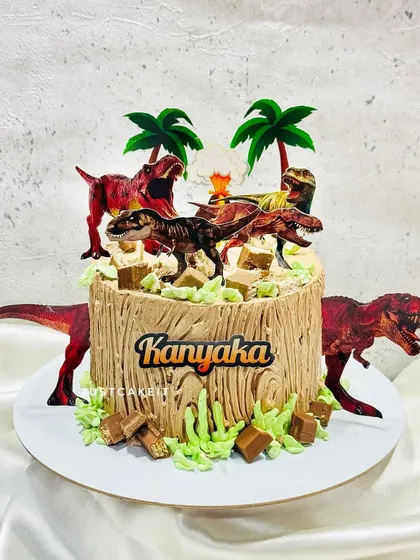 A thrilling dinosaur theme cake with a rustic, wood-like texture made from chocolate frosting. The cake is surrounded by fearsome dinosaurs, creating a prehistoric jungle scene.