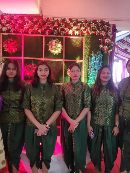 My team of hostesses in elegant traditional green uniforms, ready to welcome and assist guests at a wedding.
