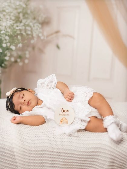 Two months new and so serene. This little one is sleeping peacefully in a simple, all-white setup that highlights her delicate features.
