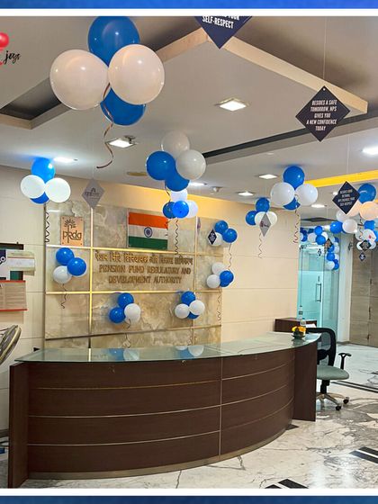 Honoring the legacy of Gandhiji with patriotic decor. This office reception for the Pension Fund Regulatory and Development Authority is decorated with blue and white balloon bunches for Gandhi Jayanti.