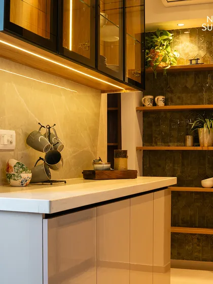 This angle highlights the smart use of vertical space, with open shelving set against a dark, textured backdrop for displaying decor. The seamless countertop and integrated lighting enhance the kitchen's clean, contemporary feel.