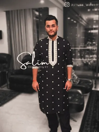 A simple yet elegant black kurta with white embroidered motifs and a detailed neckline. This is a versatile piece for any festive or formal occasion.