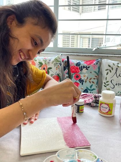 A participant enjoys a relaxing acrylic painting session, a perfect way to unwind and tap into her creativity.