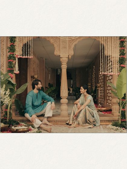 A quiet conversation on the steps of a temple, surrounded by intricate carvings and floral decor. This portrait captures a moment of peace and connection before the ceremony begins, showcasing the beauty of shared stillness.