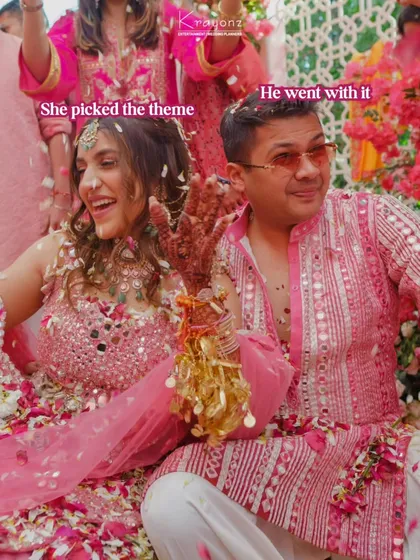 "She picked the theme, he went with it." A happy couple enjoying their pink-themed Haldi, showered with flower petals.