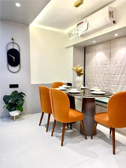 Another view of the stylish and compact dining setup. The oval table is perfect for smaller spaces, and the modern wall clock acts as a functional art piece.