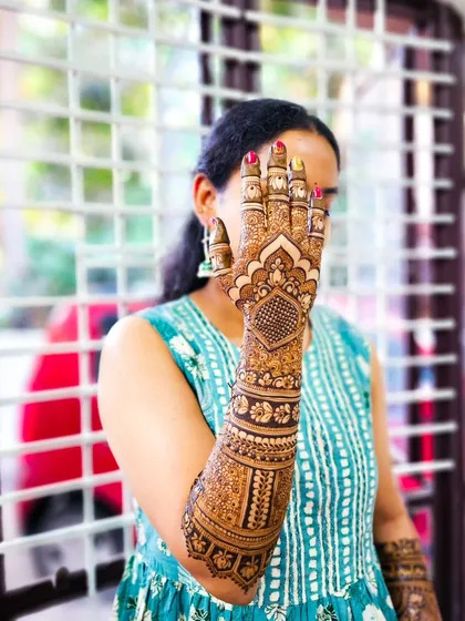 A stylish pose showing off a full arm of intricate henna work.