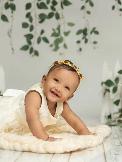 With a sweet smile, this little one crawls across a soft rug in our sunflower garden setup. The sitter stage is ideal for capturing their newfound mobility and curiosity.