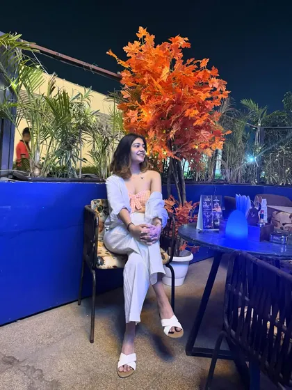 Going places. This outfit, featuring a peach-colored top and white pants, is perfect for a relaxed evening at a rooftop cafe.