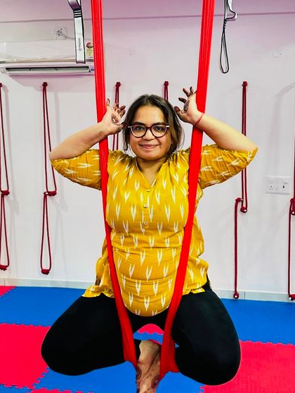 Aerial yoga is a judgment-free zone where you can be playful and expressive. This student strikes a fun pose, embracing the lighthearted spirit of our classes.