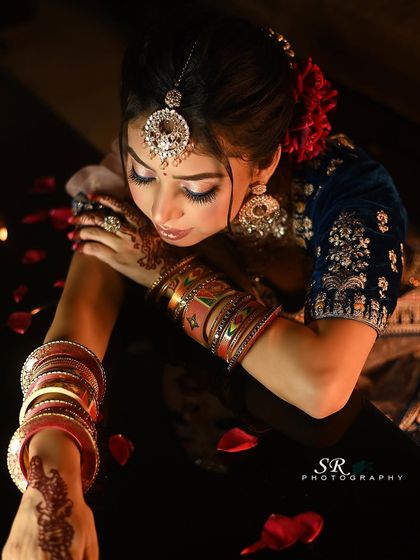 A beautiful portrait focusing on the bride's hands, adorned with henna and colorful bangles.