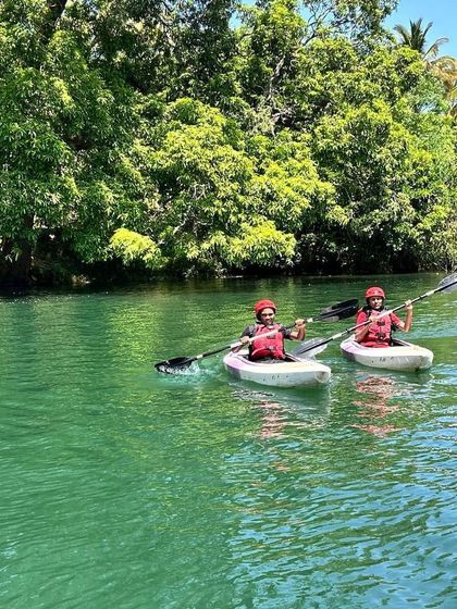 Two kayakers paddle in sync, demonstrating the skills and coordination they've developed during the camp.