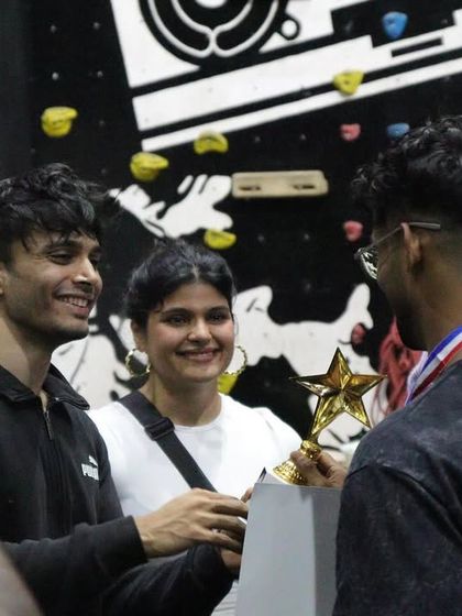 The moment of victory. An athlete receives his trophy at THE OG BAR WARS #1, surrounded by fellow competitors and judges.