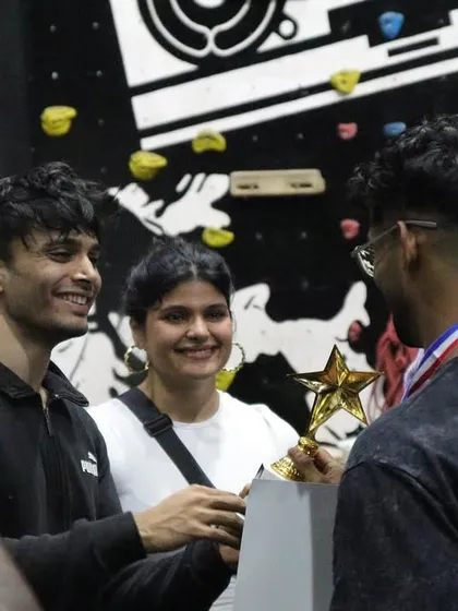 The moment of victory. An athlete receives his trophy at THE OG BAR WARS #1, surrounded by fellow competitors and judges.