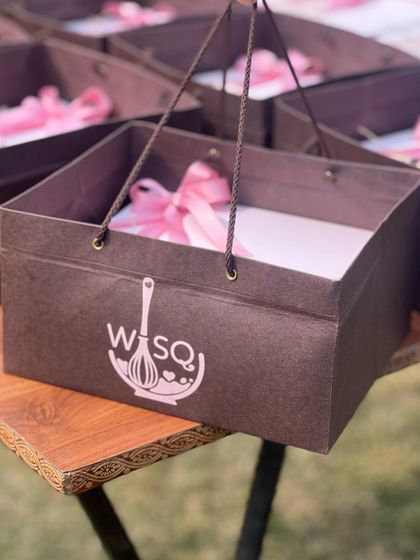 Our custom branded gift bags, designed to hold our dessert boxes. This ensures a cohesive and professional presentation from start to finish.