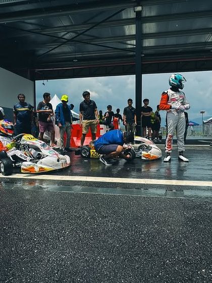 The pit lane during a wet race at the IAME Series Asia, with teams and drivers ready for action.