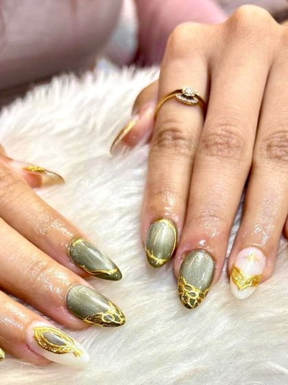 A close-up shot of the olive and gold royalty set, focusing on the statement accent nail with its detailed gold frame and cat-eye center.