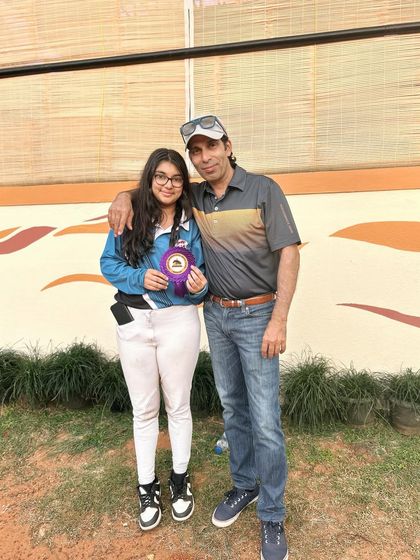 A rider posing with her father and her prize. The support of family is crucial in this sport, and we are proud to have such a strong community of parents.