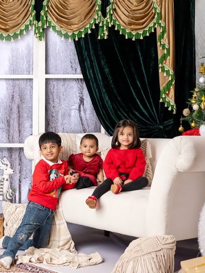 A wider shot of the children's group portrait, showing the full festive setup with the snowman and Christmas trees.
