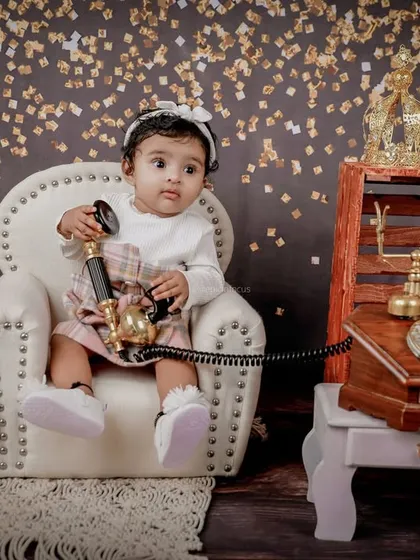 Interacting with the props is a fun part of the shoot. Here, the little girl curiously holds the receiver of a vintage telephone, creating an adorable, candid moment.